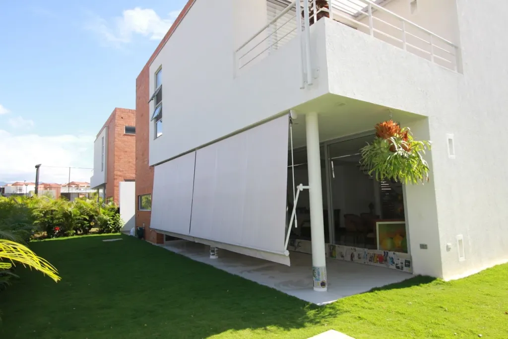 Baneta Proyectante con los brazos a 180 grados, con la lona apoyada sobre la fachada de la vivienda
