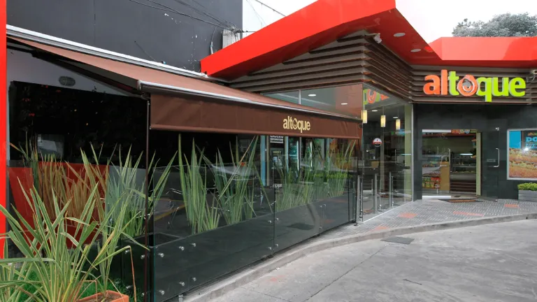 Toldo Baneta Proyectante en lona oscura proyectado sobre la terraza acristalada de un local comercial