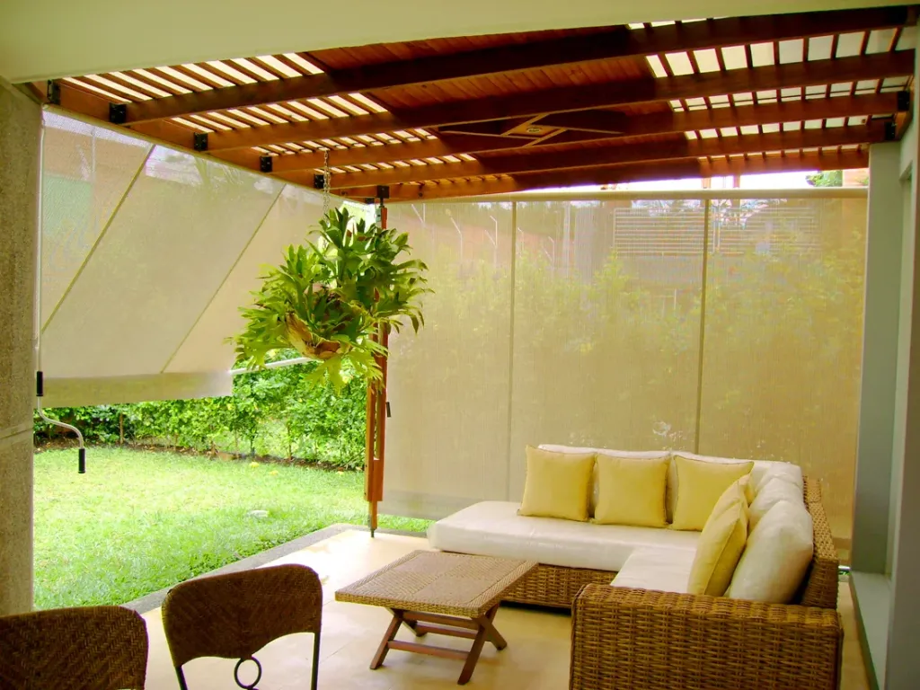 Banetas Proyectantes cerrando los laterales de una terraza cubierta con pérgola de madera