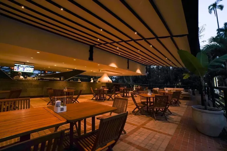Tres módulos de pérgola PergoTek Romano mini junto al bar de la piscina en Campestre