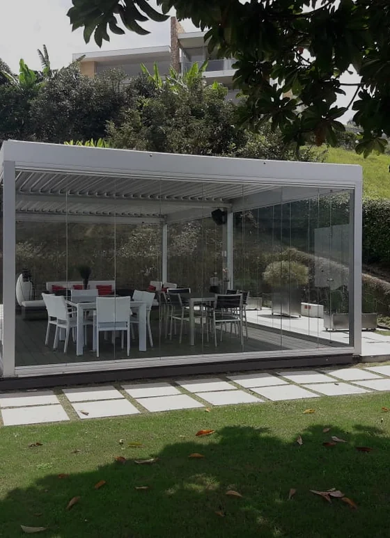 Cerramiento Slidinglass de paneles de vidrio correderos sobre una terraza con jardín