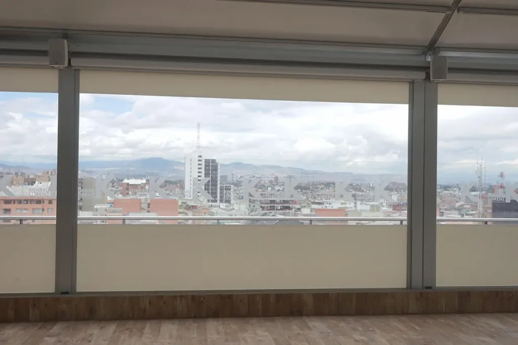 Corredor de una terraza de oficinas cerrado con FlexiZipp, con las lonas bajadas entre las guías laterales
