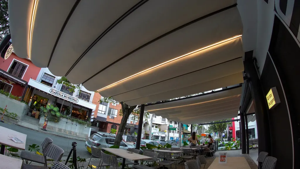 Terraza de la hamburguesería Combo en Granada, Cali, cubierta con un Pergolite eléctrico entre muros — foto 2