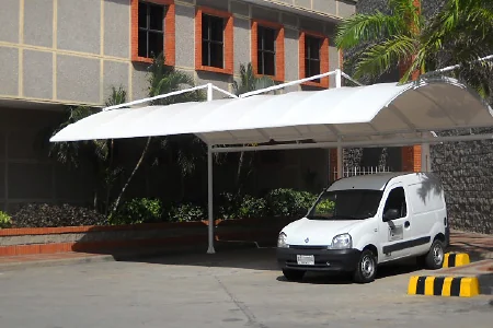 Cubrimiento para parqueadero en arco, con la cubierta de lona tensada, sobre el acceso vehicular de un edificio