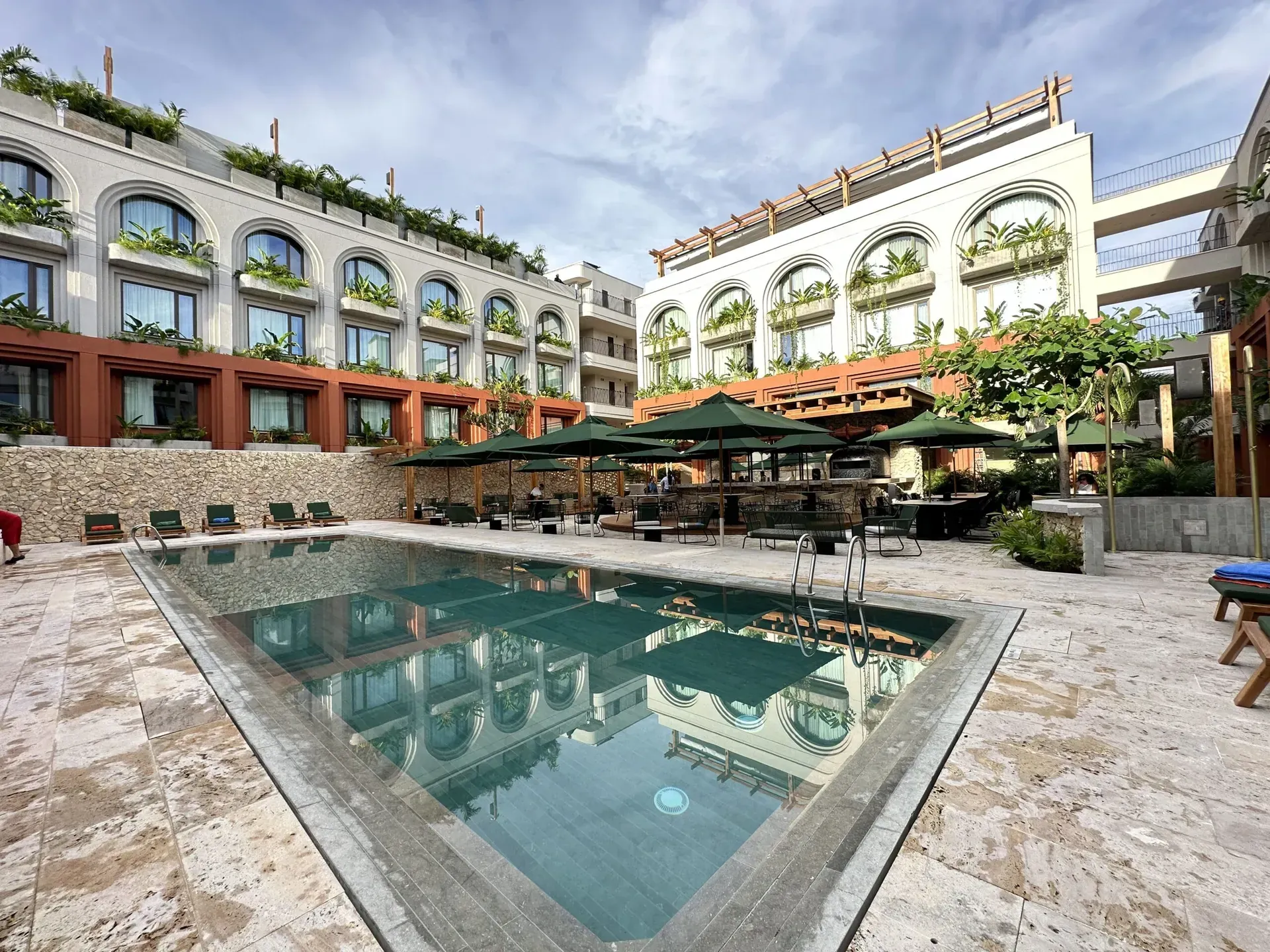 Zona exterior del Hotel OSH en Cartagena con pérgola retráctil PergoTek Romano y sombrillas