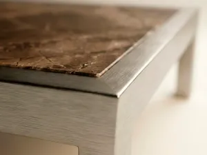 Detalle del tablero de mármol veteado con marco de aluminio de una mesa de centro de la Colección Francia