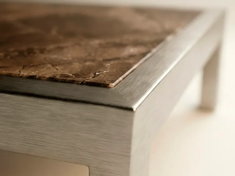 Detalle del tablero de mármol veteado con marco de aluminio de una mesa de centro de la Colección Francia