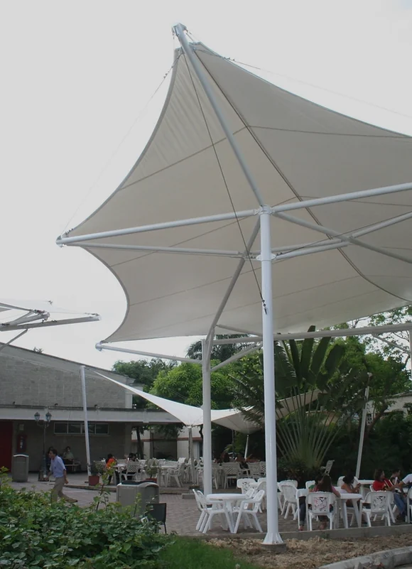Membrana autoportante en ángulo sobre una plazoleta con mesas al aire libre