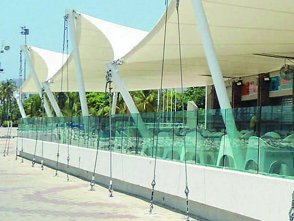 Cables de acero galvanizado y tensores de una serie de membranas de pared, anclados a un muro bajo