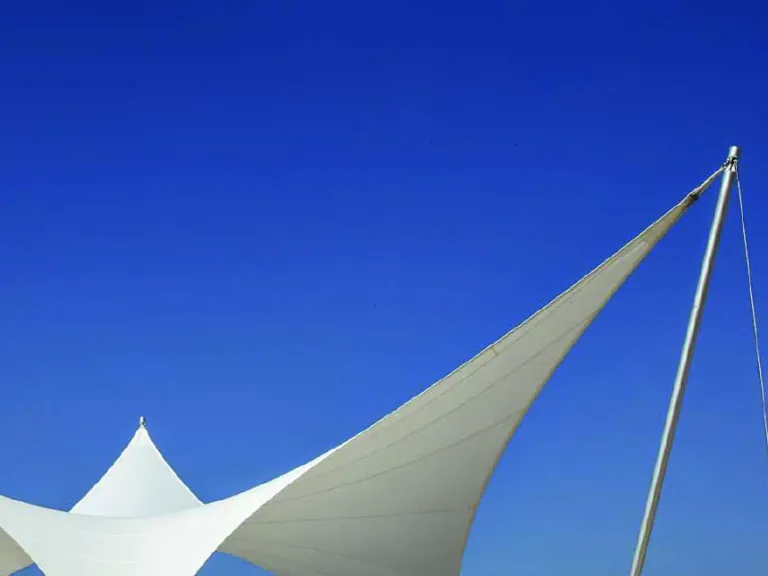 Lona PVC Dickson tensada de una membrana arquitectónica, vista a contraluz contra el cielo