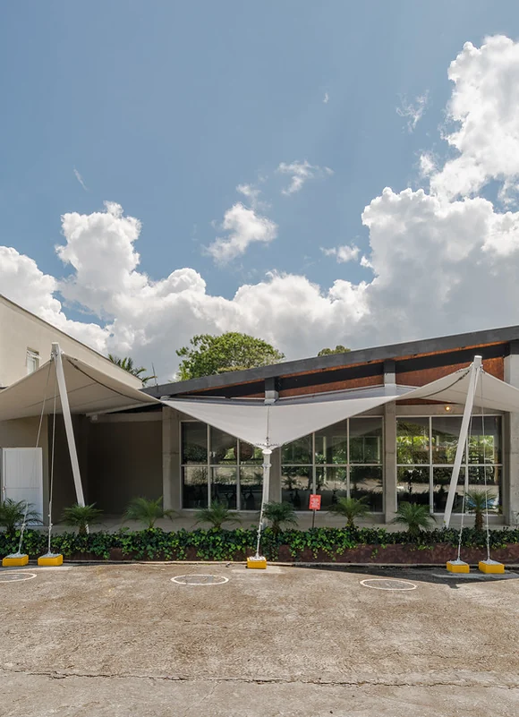 Membrana tipo pañuelo sobre la fachada de acceso de un edificio institucional