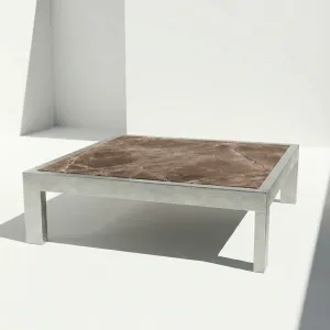 Mesa de centro Montecarlo con tablero de mármol, vista lateral sobre fondo de estudio