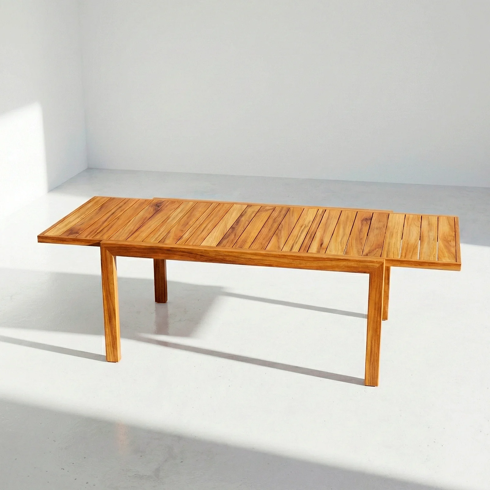 Mesa extensible Osaka en madera teca, vista frontal en fondo blanco de estudio