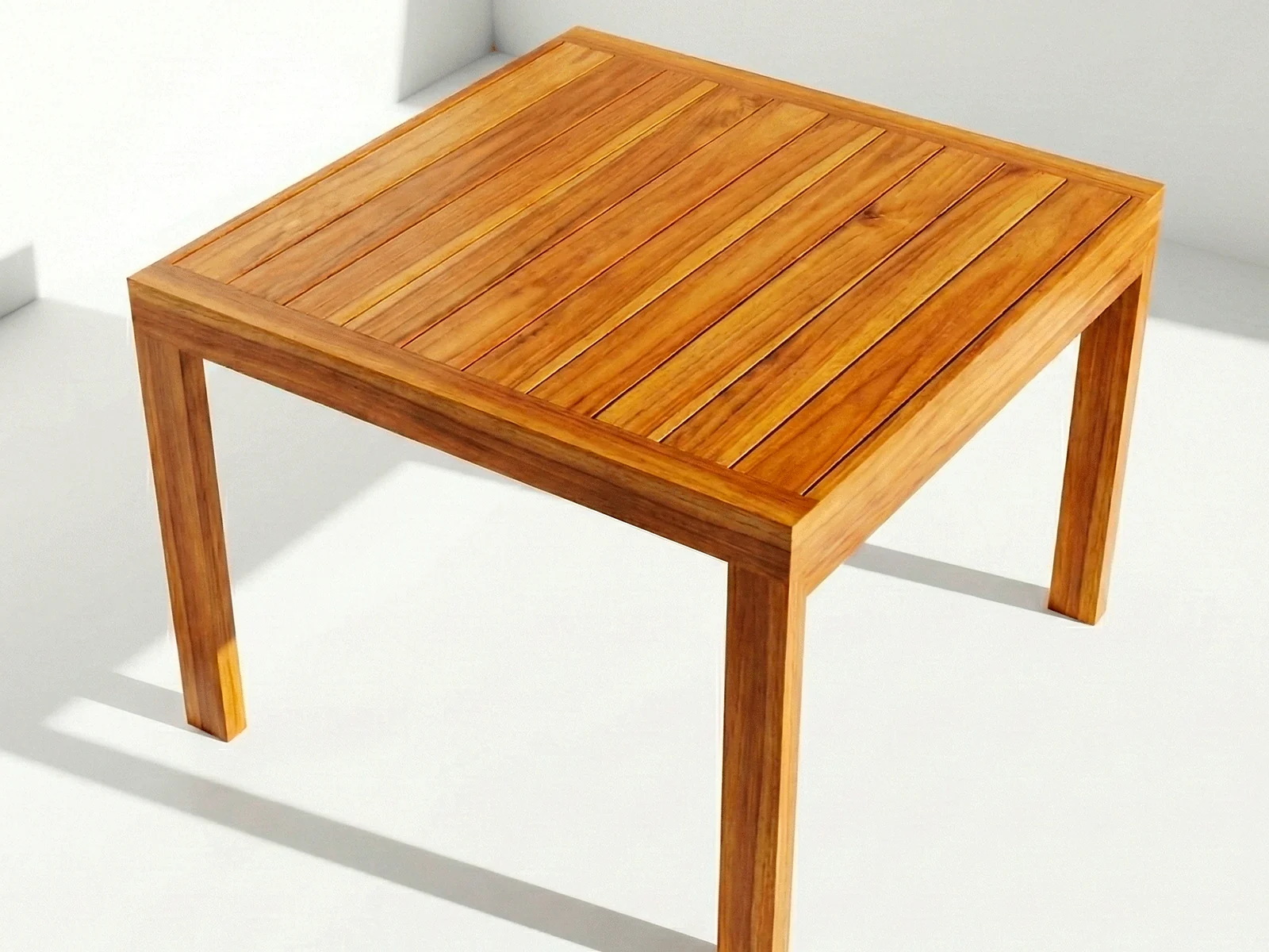 Mesa Sappai en madera teca, vista en perspectiva sobre fondo blanco de estudio