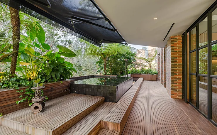 Deck de madera con toldo Sombralina y jardineras en terraza exterior