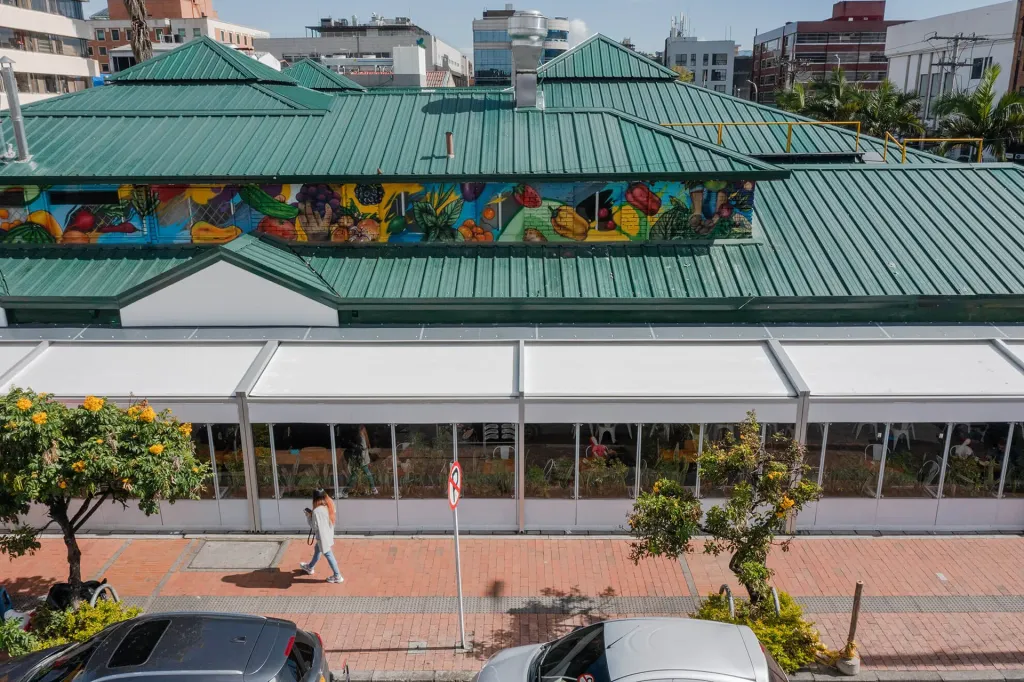Zona de mesas del rooftop del Mónaco bajo la pérgola retráctil PergoTek