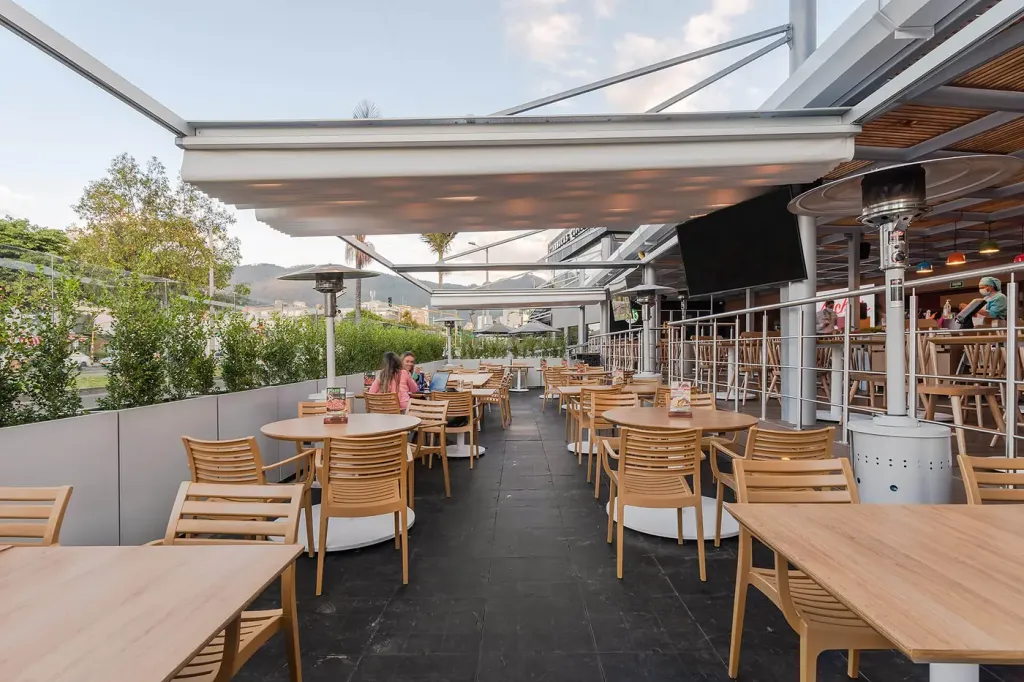 lona plegada de la pérgola retráctil sobre la terraza del restaurante en servicio