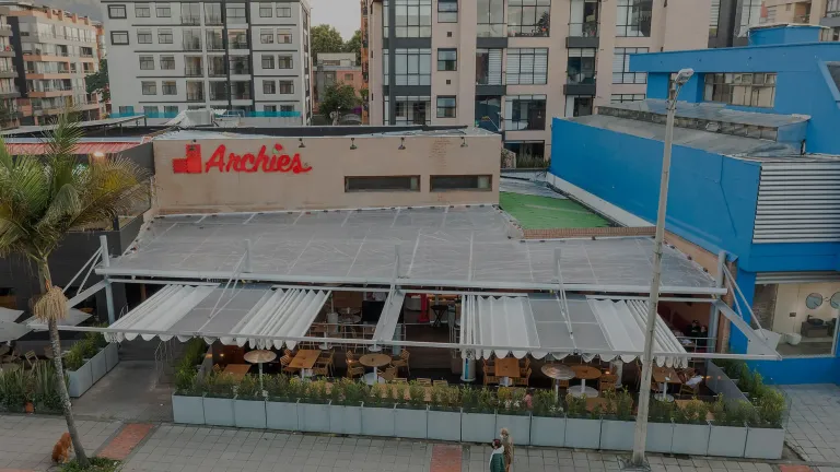 pérgola retráctil PergoFlex y pérgola fija sobre la zona de mesas exterior del restaurante Archies 116