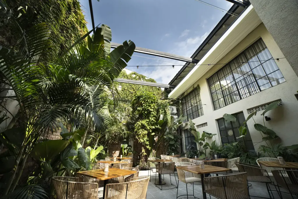 el patio del Café Gardenia con el PergoFlex recogido y el cielo abierto sobre las mesas