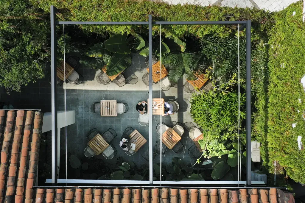 vista cenital del patio del Café Gardenia con la pérgola retráctil recogida y las mesas ocupadas