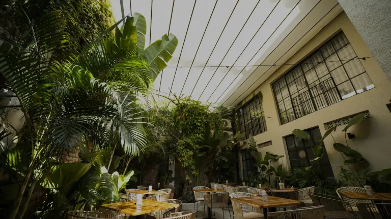 pérgola retráctil PergoFlex desplegada sobre las mesas exteriores del Café Gardenia