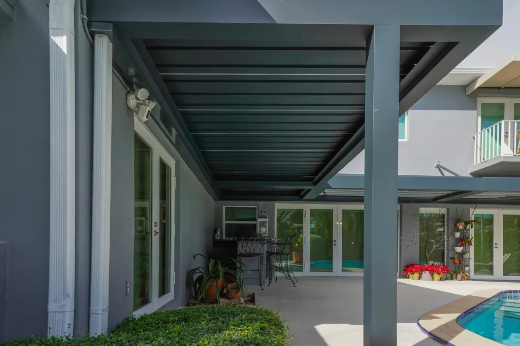 Lamas de aluminio de una pérgola bioclimática PergoLam vistas desde abajo, cerradas herméticamente sobre un patio