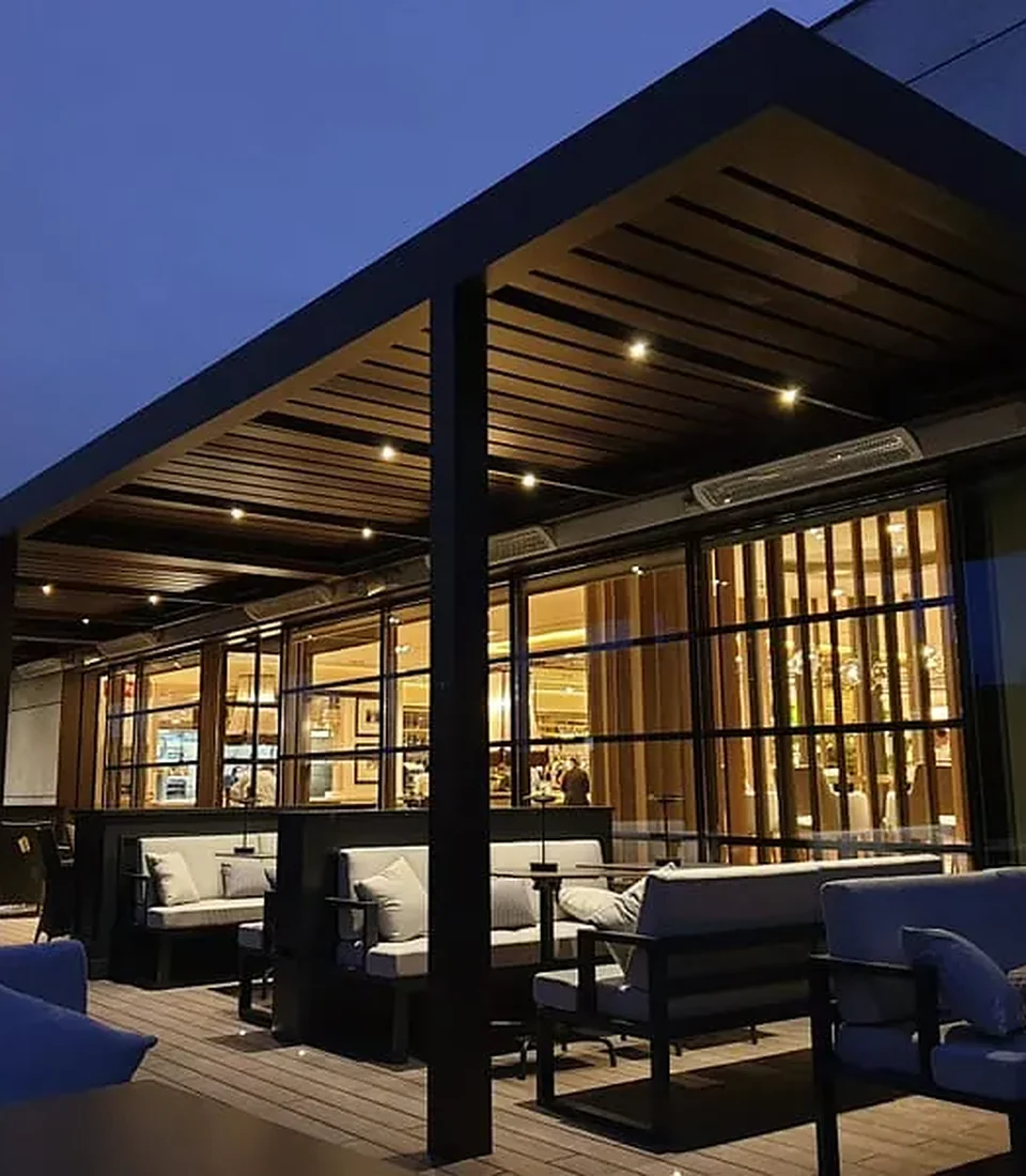 Pérgola bioclimática retráctil en terraza de vivienda al atardecer