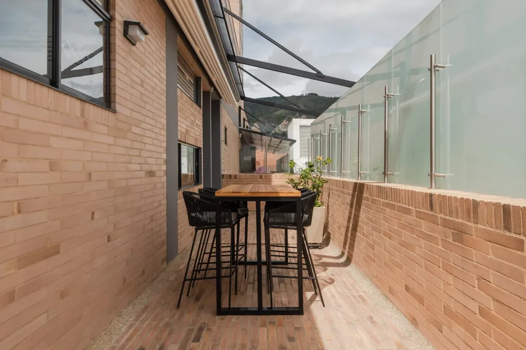 brazos y perfiles de aluminio de la pérgola retráctil con la lona recogida sobre el balcón