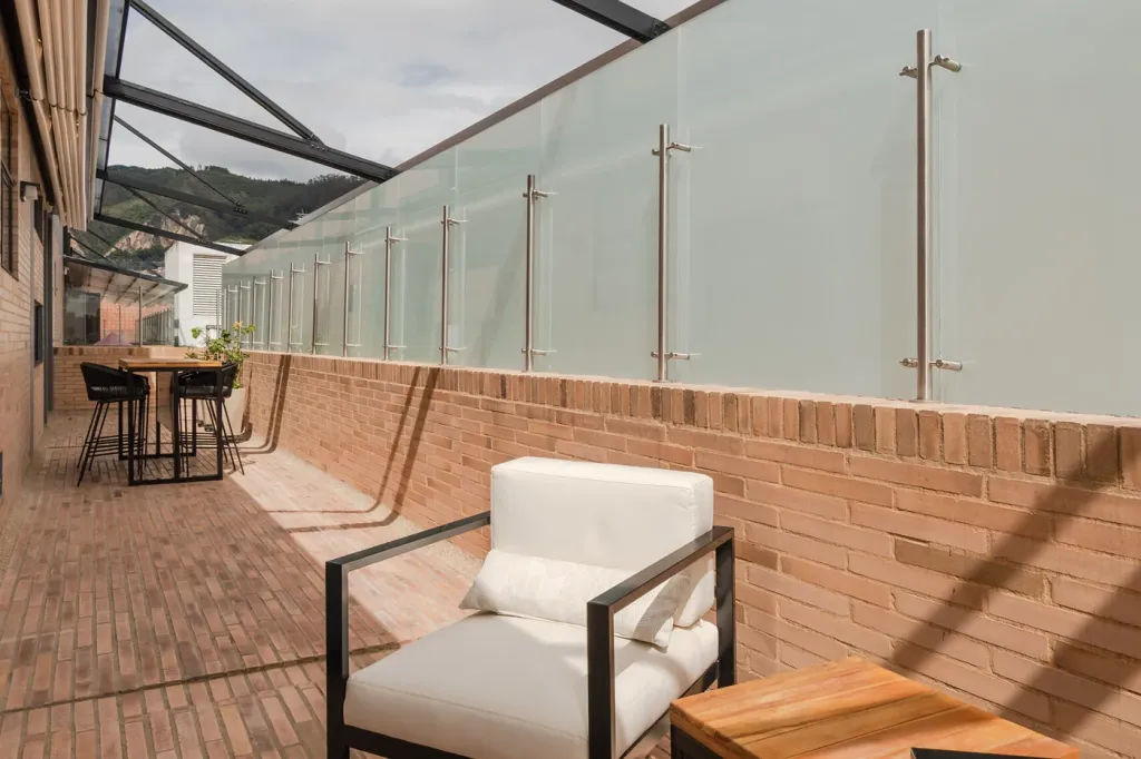 rincón de butacas del balcón con la pérgola retráctil recogida y los cerros al fondo