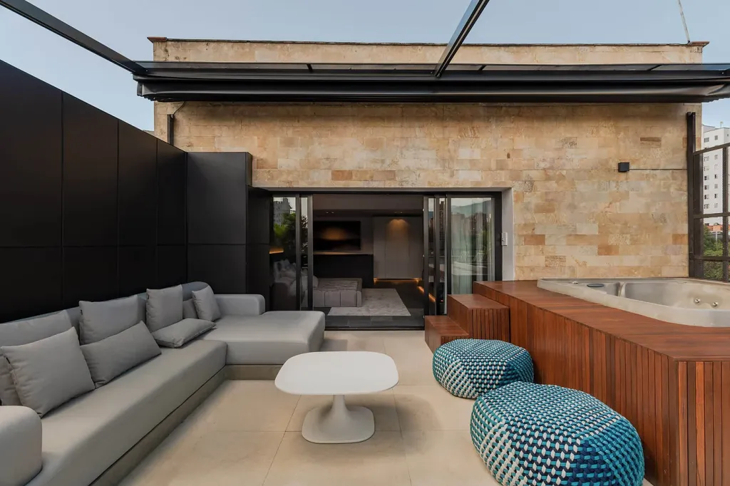 sala exterior y jacuzzi bajo la pérgola retráctil recogida en la terraza de un apartamento