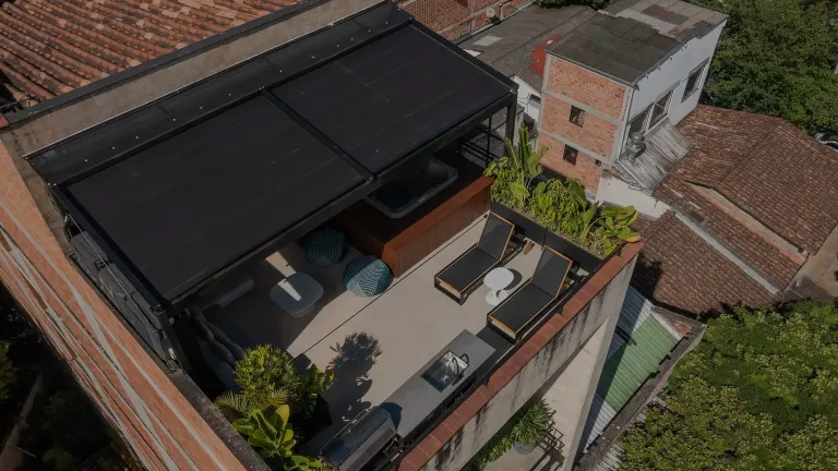 pérgola retráctil desplegada sobre la terraza en cubierta de un apartamento, vista desde el aire