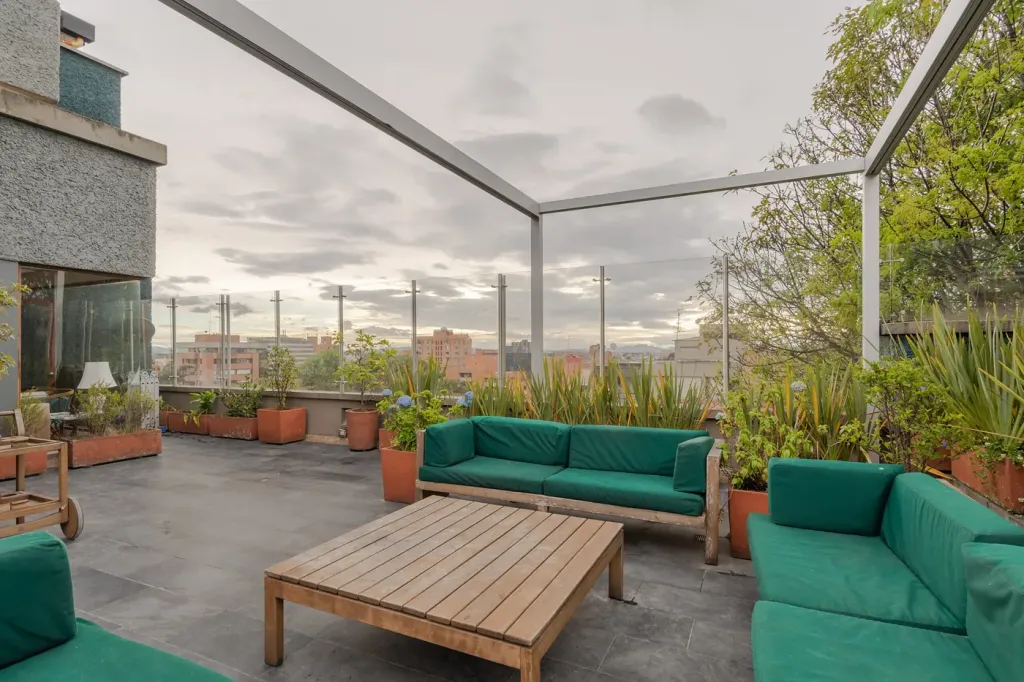 estructura de aluminio de la pérgola retráctil sin la lona, sobre el segundo rincón de sofás de la terraza
