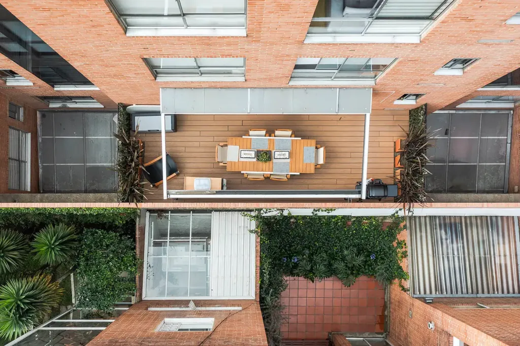 vista cenital de la terraza en Bogotá con la lona de la pérgola retráctil recogida sobre el comedor