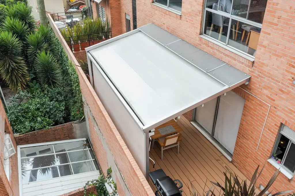 lona de la pérgola retráctil extendida y tensada sobre el deck de la terraza, en Bogotá