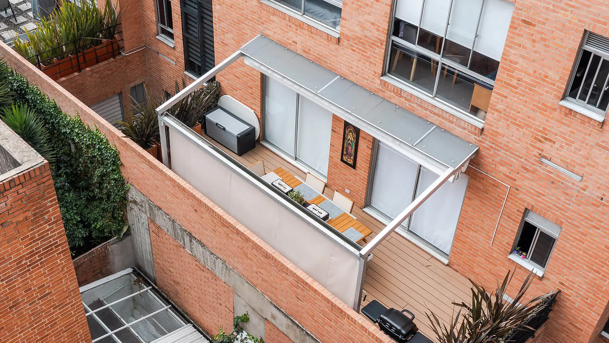 pérgola retráctil de aluminio anodizado gris sobre la terraza de un apartamento en Bogotá