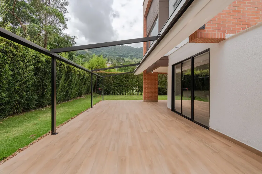 pérgola retráctil recogida sobre el deck: la estructura deja el jardín y el valle abiertos
