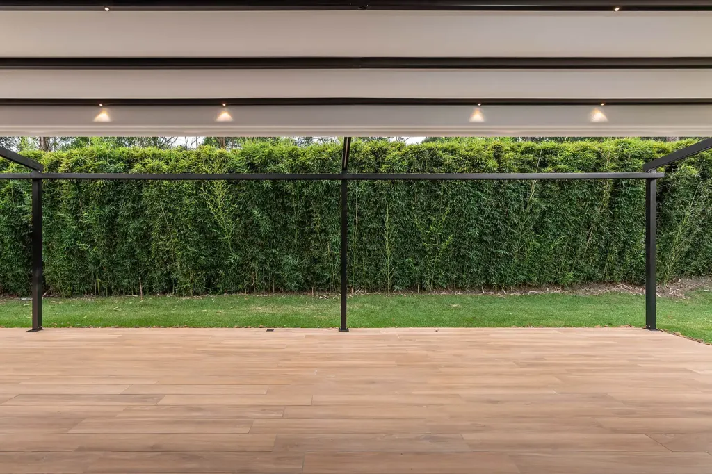 lona e iluminación integrada de una pérgola retráctil desplegada, vista desde el jardín