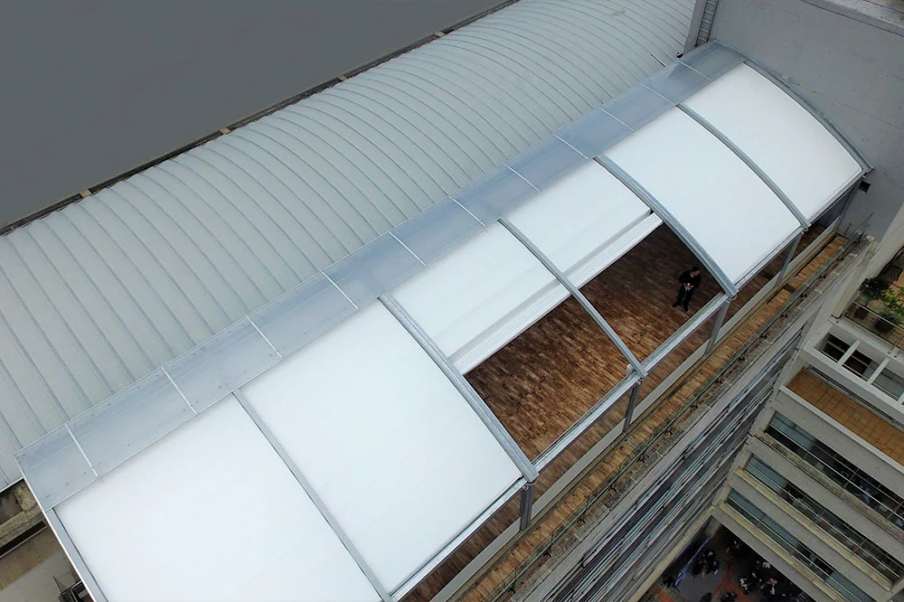 Pérgola retráctil PergoDom vista desde un dron con el domo parcialmente abierto sobre el salón, Bogotá