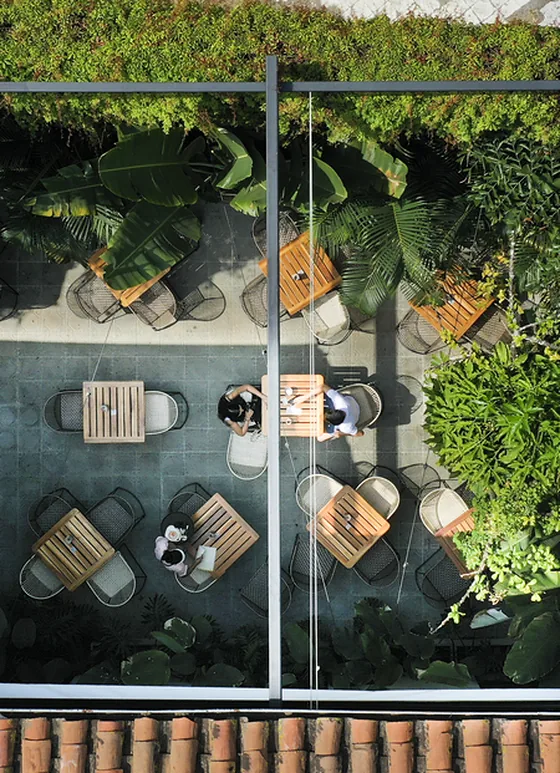 Pérgola retráctil PergoFlex sobre un patio interior con jardín vertical