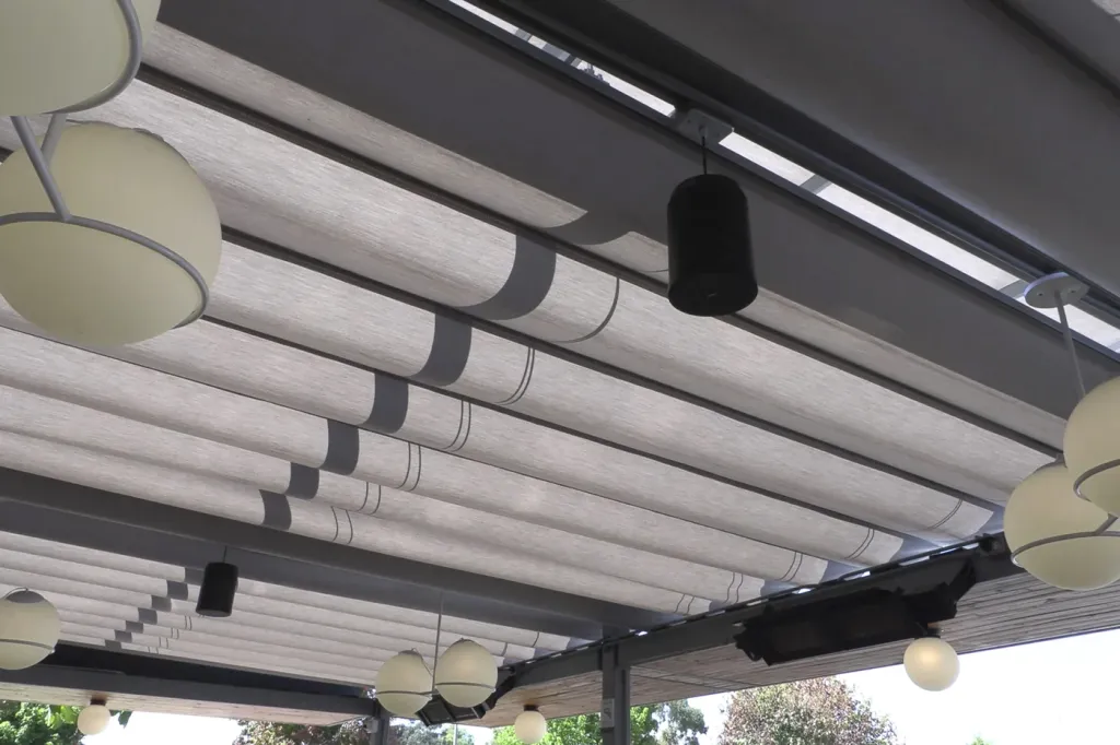 Detalle de los pliegues e iluminación integrada de la pérgola retráctil Pergolite en Home Burger, Bogotá