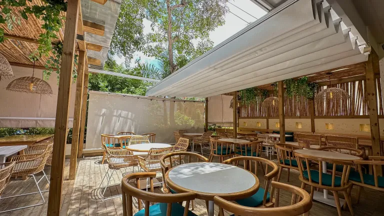 Pérgola retráctil Pergolite abierta sobre la terraza del restaurante Harissa Food