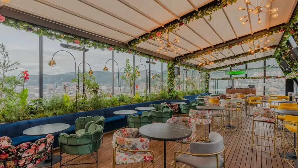 Terraza de rooftop cubierta con pérgola retráctil de lona, jardineras y zona de estar