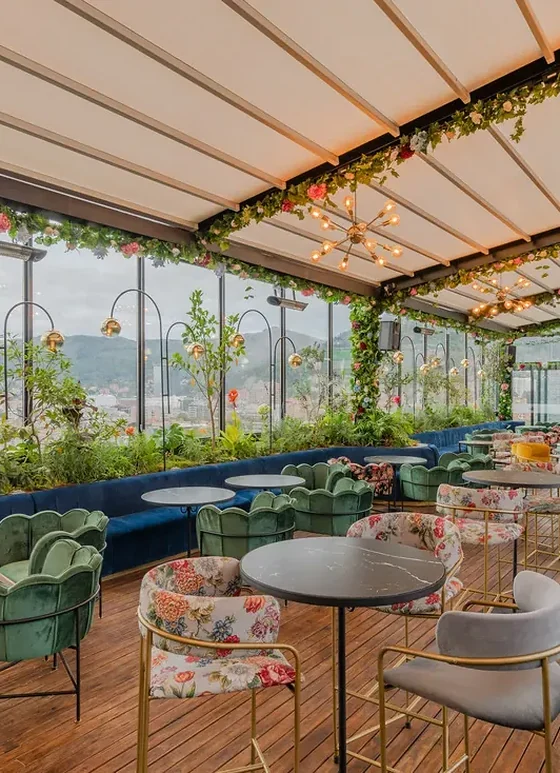 Terraza de rooftop cubierta con pérgola retráctil de lona y jardineras colgantes