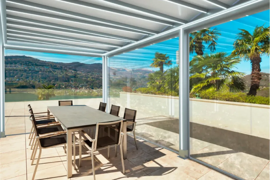 Comedor exterior bajo una pérgola PergoTek Design de marco perimetral blanco