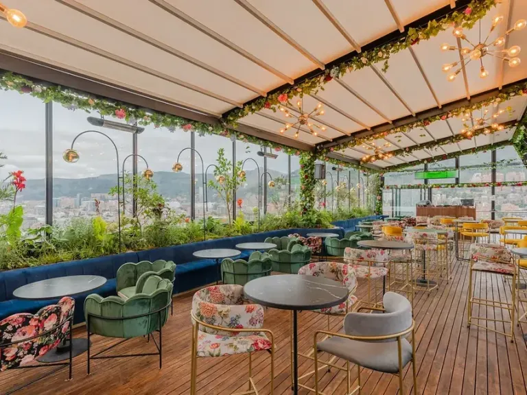 Pérgola retráctil PergoTek de lona tensa con pendiente pronunciada sobre una terraza con jardineras
