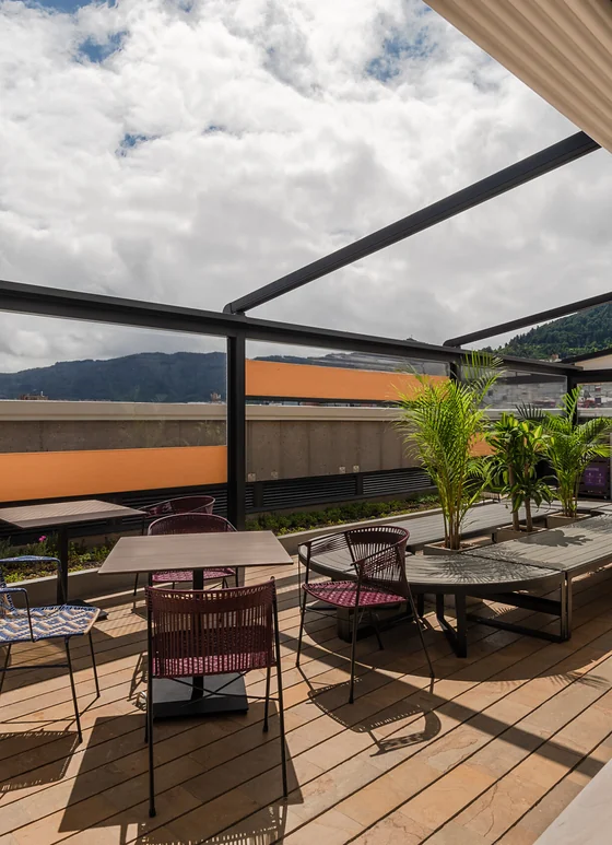 Pérgola retráctil PergoTek abierta sobre postes en una terraza, con la lona recogida y el cielo a la vista