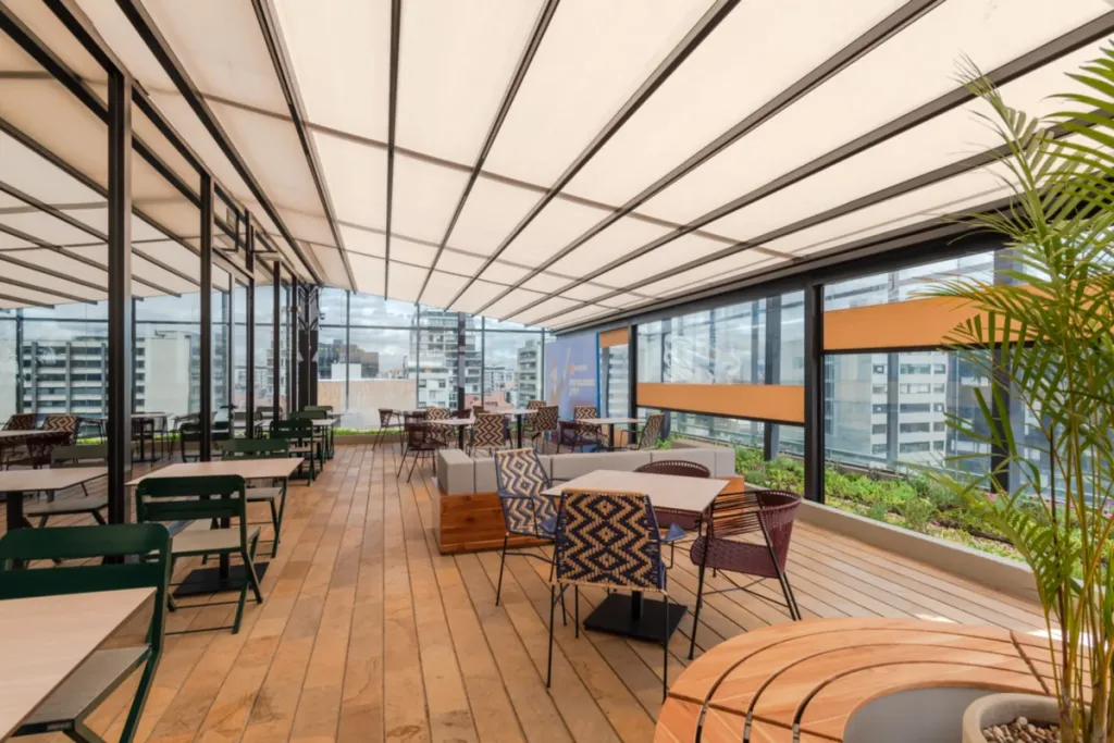 Pérgola retráctil PergoTek sobre un deck de madera con vista a la ciudad