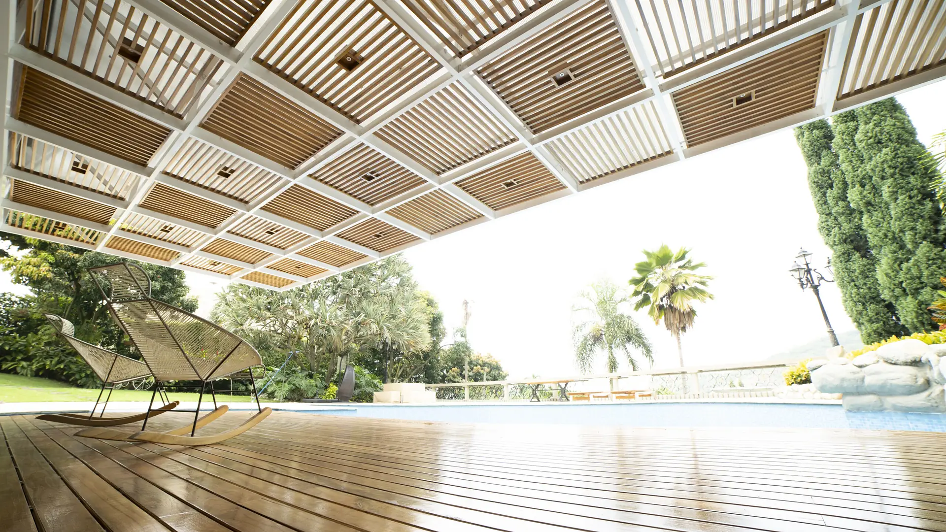 Pérgola fija de aluminio y madera teca sobre el deck de una piscina exterior