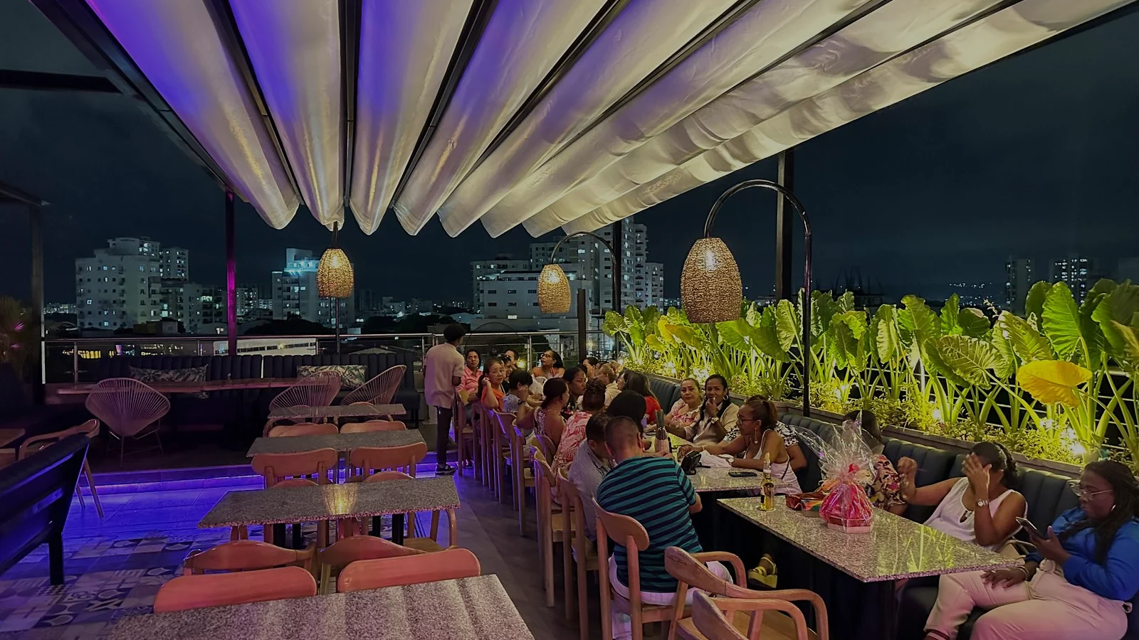pérgola retráctil PergoTek desplegada e iluminada sobre la terraza del restaurante Ritual