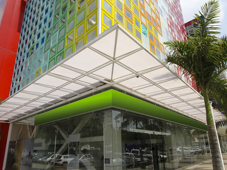 Cubierta fija en policarbonato con estructura blanca de aluminio sobre el acceso del Edificio de Colores, Cali